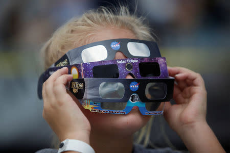 Ariana Mareyev, 10, of Charleston wears several pairs of solar glasses on the flight deck of the Naval museum ship U.S.S. Yorktown in Mount Pleasant, South Carolina. REUTERS/Randall Hill