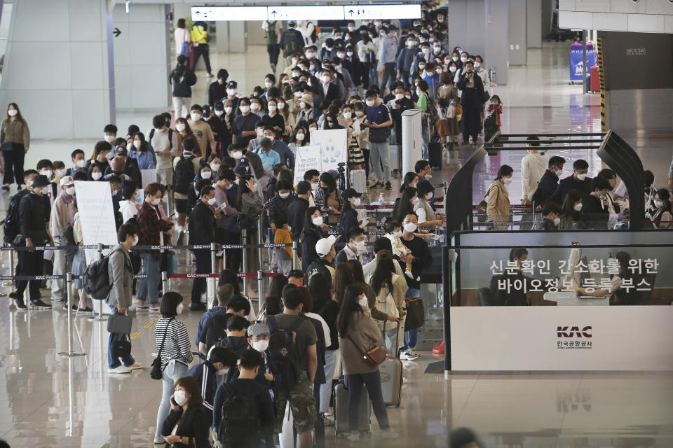 Passengers wearing face masks to help protect against the spread of the coronavirus line up to board planes ahead of the upcoming Chuseok holiday, the Korean version of Thanksgiving Day, at the domestic flight terminal of Gimpo airport in Seoul, South Korea, Wednesday, Sept. 30, 2020. (AP Photo/Ahn Young-joon)