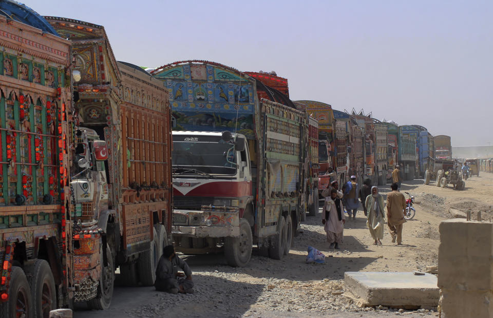 Delivery trucks inbound for Afghanistan wait to move towards the Afghan side at a border crossing point, in Chaman, Pakistan, Wednesday, Aug. 18, 2021. Chaman is a key border crossing between Pakistan and Afghanistan, normally thousands of Afghans and Pakistanis cross daily and a steady stream of trucks passes through, taking goods to Afghanistan. (AP Photo/Jafar Khan)