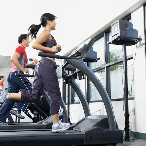 People running on treadmills in gym