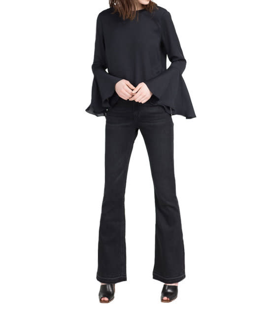 A bell-sleeved blouse adds a retro ‘70s vibe to a normally-drab all-black ensemble. 