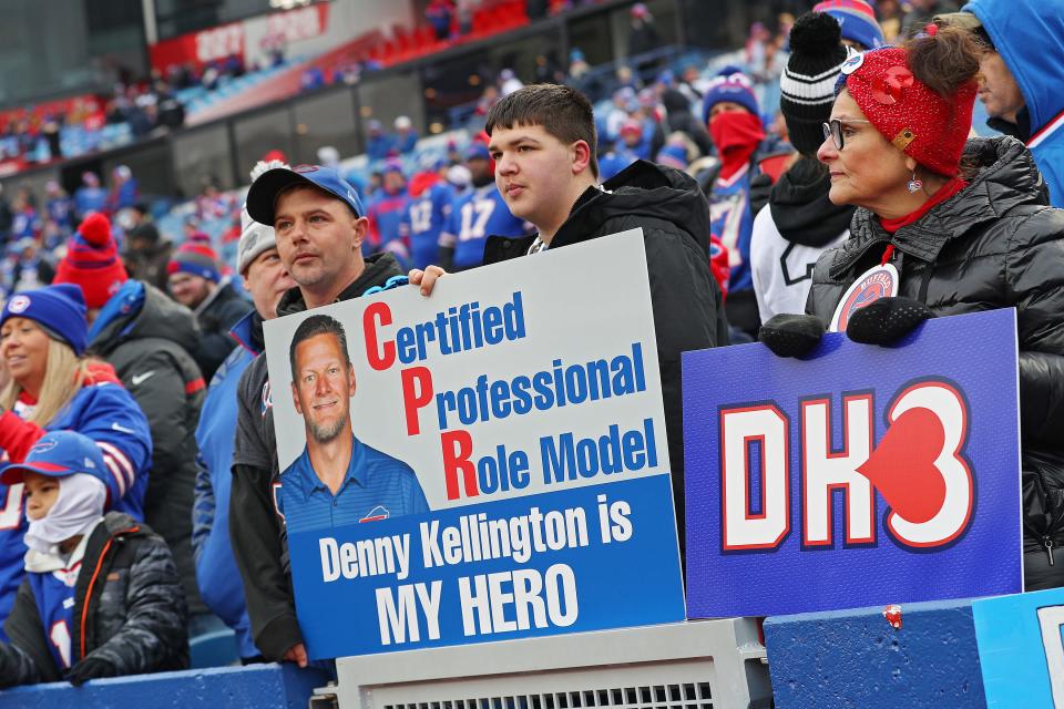 Buffalo Bills fan hold signs in support of Buffalo Bills safety Damar Hamlin and Denny Kellington.