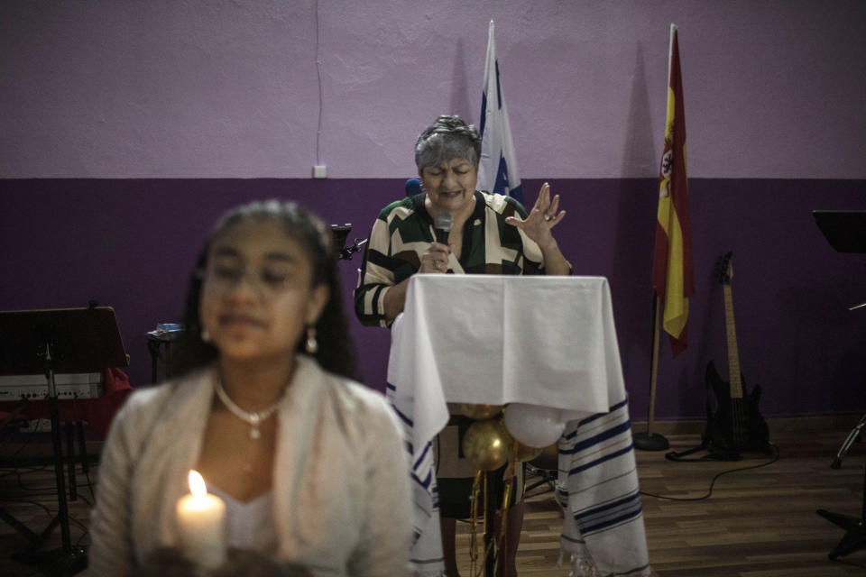 Argentinian Pentecostal Pastor Nedyt Lescano, 62, leads a rite of passage ceremony for Melanie Villalobos Enriquez, from Venezuela, left, and other teenagers turning 13, in Salamanca, Spain, Saturday, Dec. 4, 2021. “Unlike the Catholic church, we don’t receive any subsidies. We do it all by our own efforts here,” Lescano says. (AP Photo/Manu Brabo)