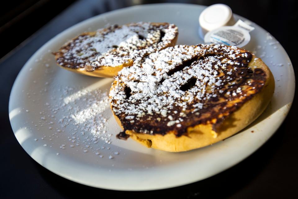 A French toast cinnamon roll topped with powdered sugar and served with a side of butter at Hamburg Inn No. 2 in Iowa City.