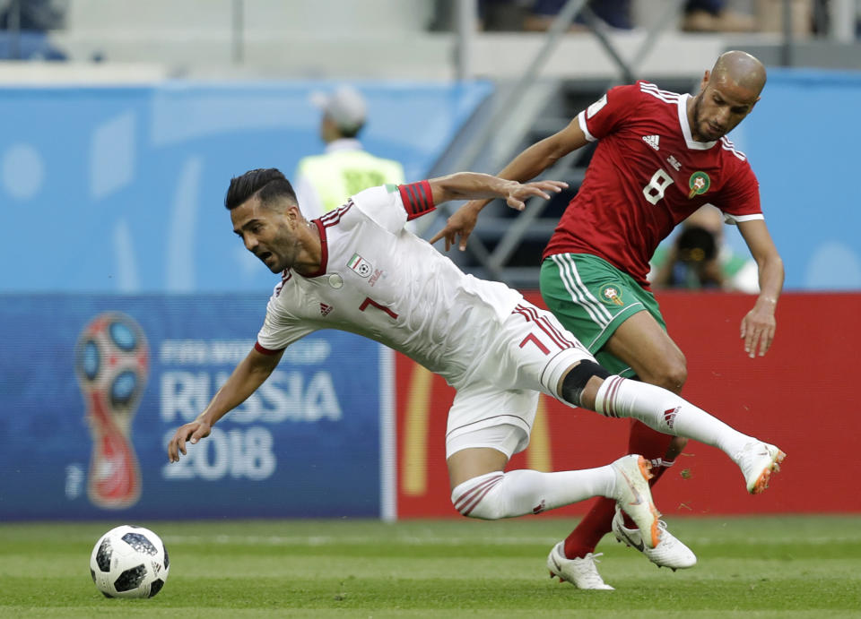 <p>Brought down: Iran’s Masoud Shojaei is tackled by Morocco’s Karim El Ahmadi. (AP) </p>