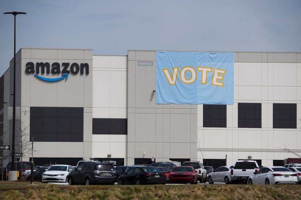 Vote signage hangs outside the Amazon.com, Inc. fulfillment center in Bessemer, Alabama on March 26, 2021. - Senator Bernie Sanders joined the drive March 26, 2021, to unionize Amazon workers in Alabama with the Retail, Wholesale and Department Store Union (RWDSU) in Birmingham, as clashes intensified between lawmakers and the e-commerce giant ahead of a deadline for a vote that could lead to the first union on US soil at the massive tech company. The visit marks the latest high-profile appearance in the contentious organizing effort for some 5,800 employees at Amazon's warehouse in Bessemer which culminates next week. (Photo by Patrick T. FALLON / AFP) (Photo by PATRICK T. FALLON/AFP via Getty Images)