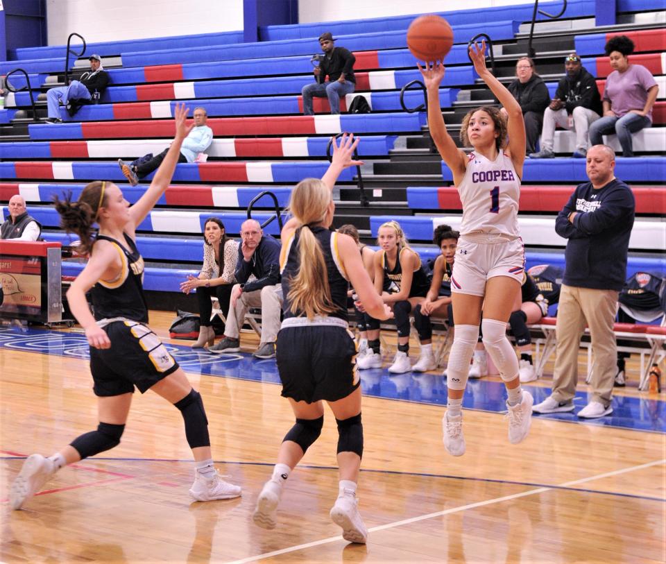 Cooper's Jazlyn Hatcher (1) shoots over a pair of Stephenville defenders while Stephenville coach Jason Hodges looks on in the first quarter.