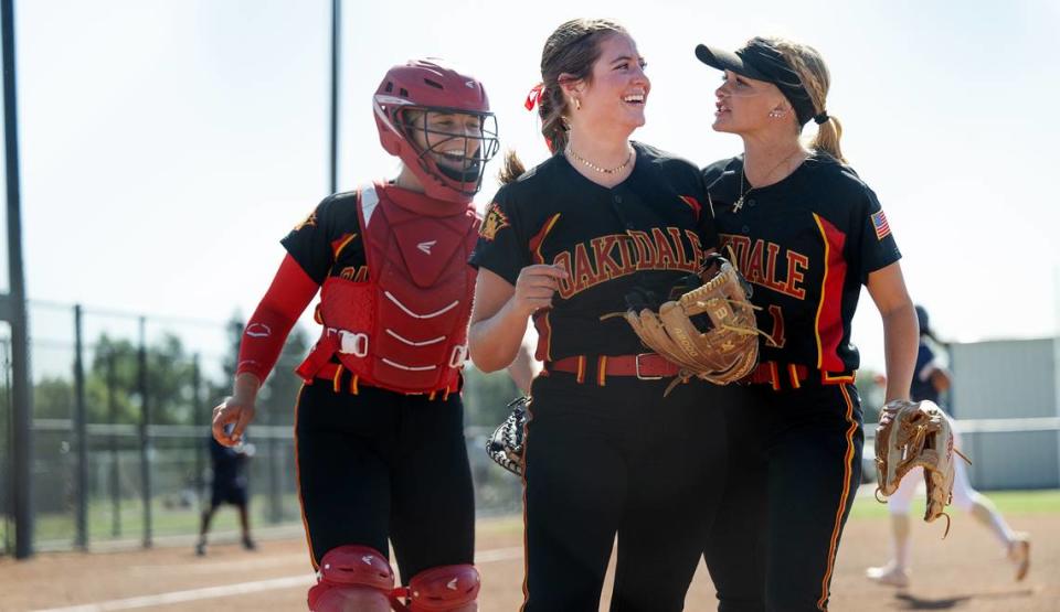 Oakdale players Raegen Everett, middle, Jayci Volonte, right, and Presley Barnes, left, walk off the field after closing out the side of Central Catholic hitters during the Valley Oak League game at Central Catholic High School in Modesto, Calif., Tuesday, May 8, 2024. Everett struck out seven batters in seven innings in the 6-3 Oakdale win.
