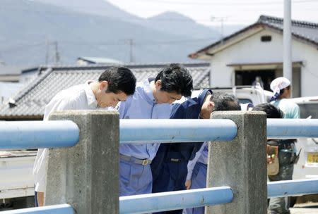 Japan's Prime Minister Shinzo Abe (2nd L) pays a silent tribute to the victims of torrential rain at Nomura town in Seiyo, Ehime Prefecture, Japan, in this photo distributed by Kyodo July 13, 2018. Mandatory credit Kyodo/via REUTERS