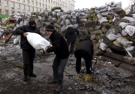 Anti-government protesters chop and collect ice for the construction of barricades at the site of clashes with riot police in Kiev, January 27, 2014. REUTERS/Vasily Fedosenko