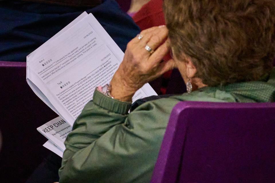 A Chandler resident reads one-star reviews of other Dominium properties from a printed packet during a town-hall at Hamilton High School in Chandler, on Wednesday, Jan. 25, 2023.