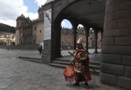 A man dressed as Inca ruler Manco Capac, who according to some historians was the first governor and founder of the Inca civilization in Cusco waits for tourists on an empty street in modern-day Cusco, Peru, Monday, Oct. 26, 2020. All major sites around the Cusco are currently open for free, in hopes of sparking any tourism after the COVID-19 pandemic brought it to a standstill, leaving reenactors like this man interpreting Manco Capac facing severe unemployment. (AP Photo/Martin Mejia)