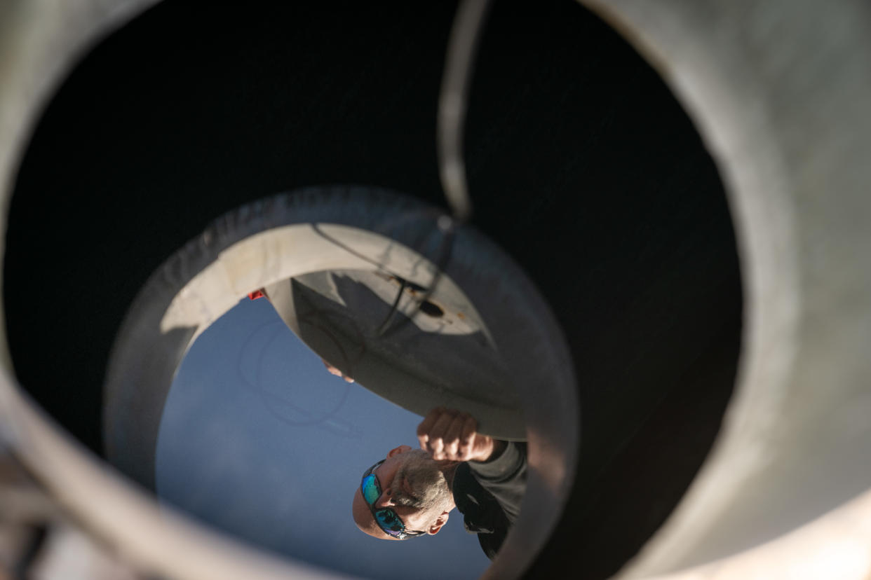 Russell Cox, un residente, se refleja en el agua de su tanque subterráneo de almacenamiento de agua en Río Verde, Arizona, el domingo 8 de enero de 2023. (Erin Schaff/The New York Times).