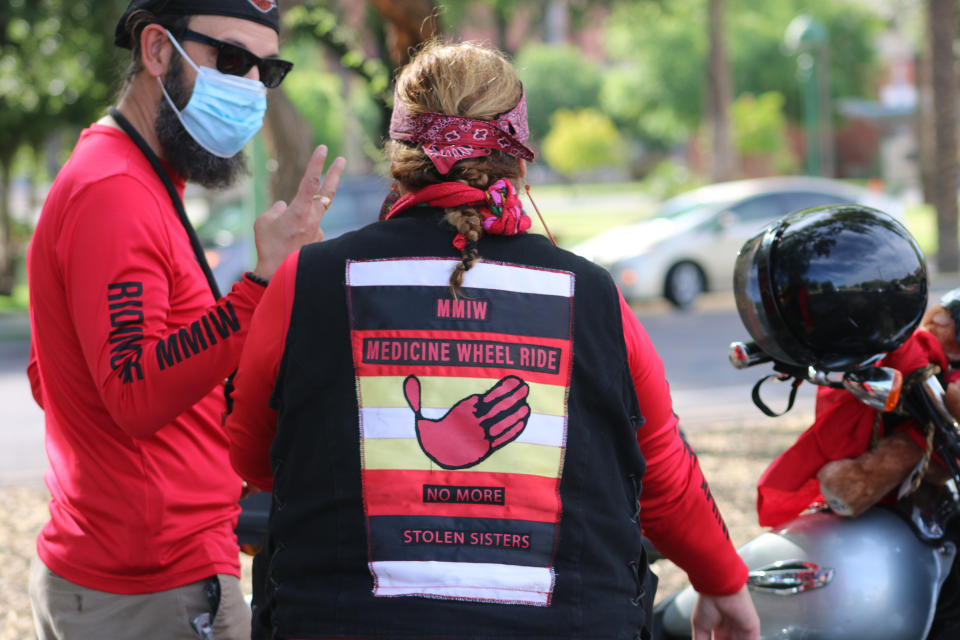 Members from Medicine Wheel Ride stand by their bikes tied with red ribbons at the Arizona State Capitol in Phoenix, Wednesday, May 5, 2021, after riding to raise awareness for missing and murdered Indigenous women and girls. (AP Photo/Cheyanne Mumphrey)