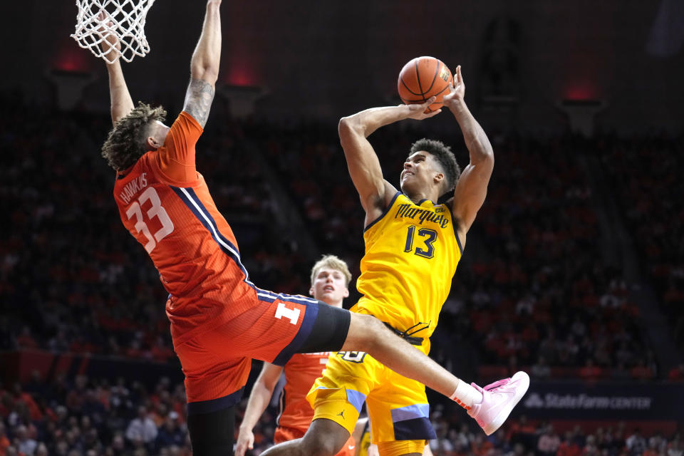 Marquette forward Oso Ighodaro (13) shoots over Illinois forward Coleman Hawkins during the second half of an NCAA college basketball game Tuesday, Nov. 14, 2023, in Champaign, Ill. (AP Photo/Charles Rex Arbogast)