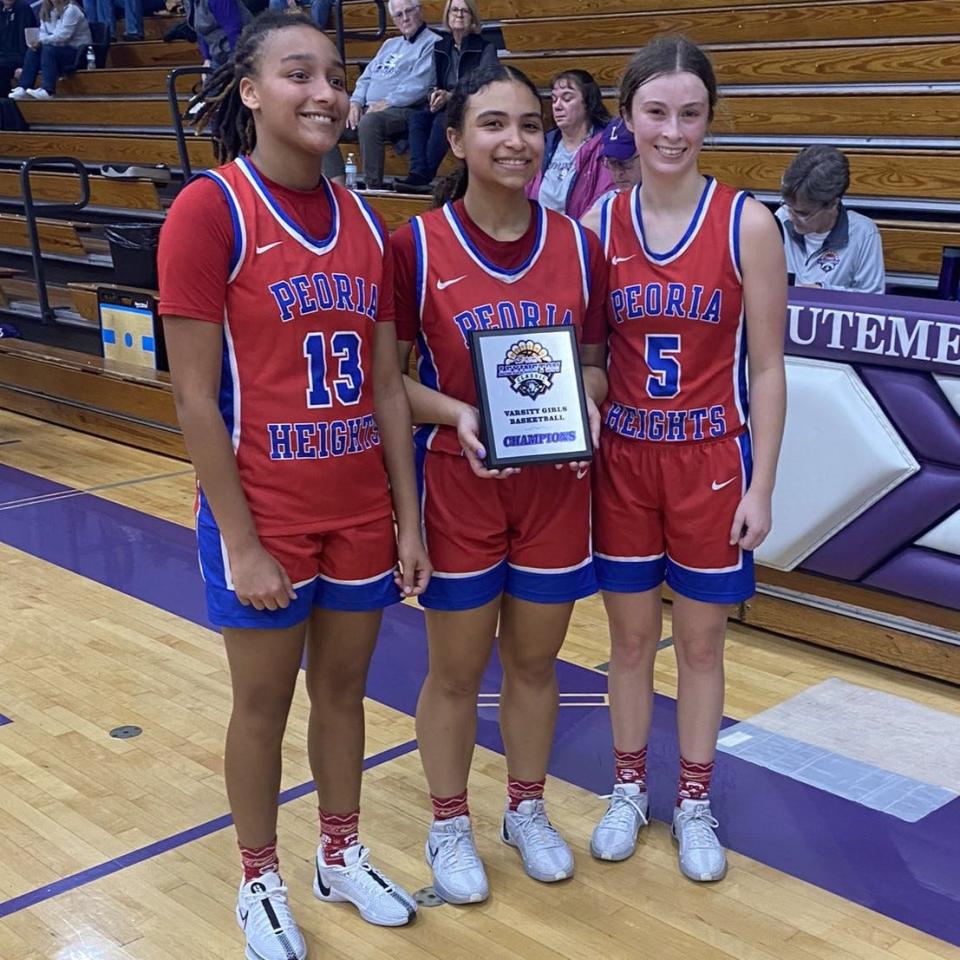 Peoria Heights senior Janessa Wallace, center, holds the plaque after helping the Patriots win the Lexington Classic on Nov. 16. Senior Emily Dana, right, and Tania Cox, left, pose with Wallace.