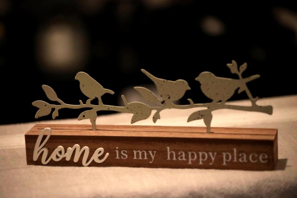 A decoration, "home is my happy place," rests on a living room table inside the Rojas family's apartment.