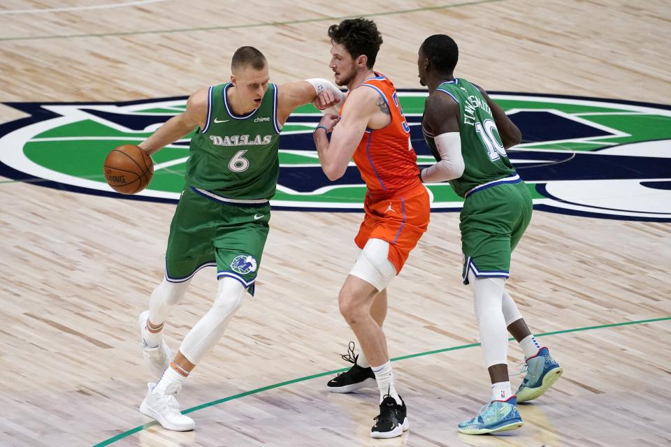 Dallas Mavericks center Kristaps Porzingis (6) works around Oklahoma City Thunder center Mike Muscala, center, with help from forward Dorian Finney-Smith (10) in the first half of an NBA basketball game in Dallas, Wednesday, March 3, 2021. (AP Photo/Tony Gutierrez)