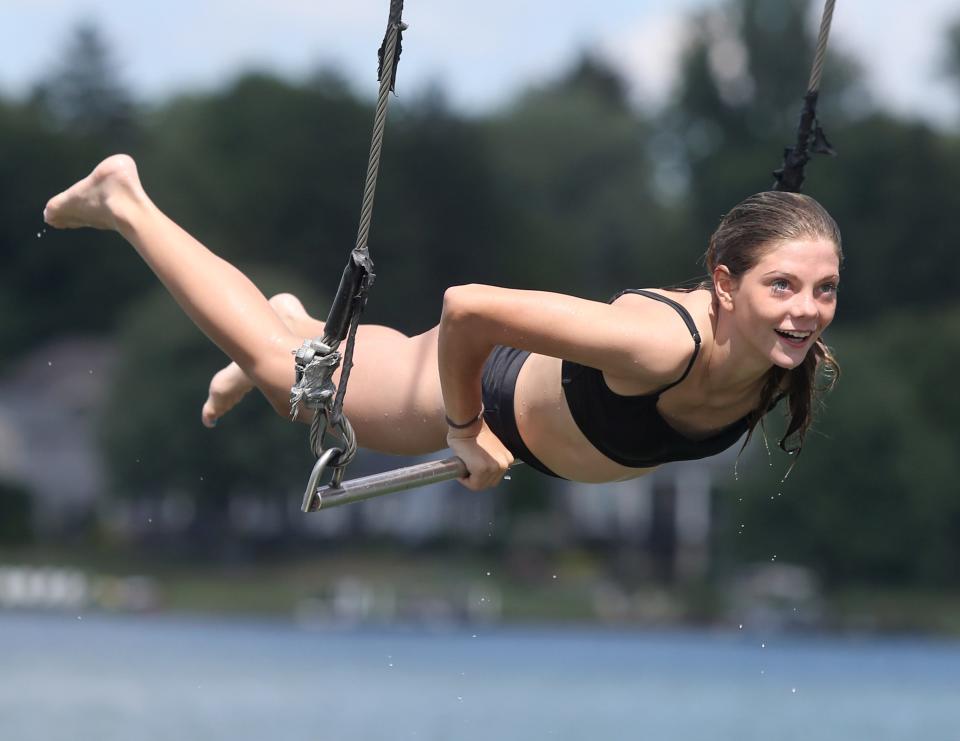 Remi Groomes rides the trapeze over Lake Cable in Jackson Township.