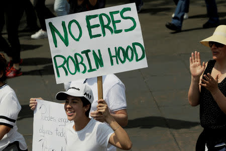 A demonstrator holds a sign during a march against the government of Mexico's President Andres Manuel Lopez Obrador in Mexico City, Mexico May 5, 2019. The sign reads, "You're not Robin Hood". REUTERS/Luis Cortes