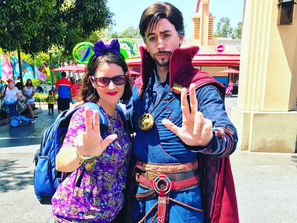 sarah posing with dr strange doing his signature pose at disneyland avengers campus