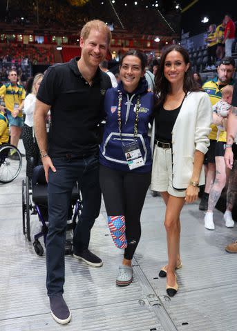 <p>Chris Jackson/Getty</p> Prince Harry and Meghan Markle pose with U.S. veteran Annika Hutsler