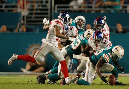 Dec 14, 2015; Miami Gardens, FL, USA; New York Giants running back Andre Williams (44) fumbles and Miami Dolphins safety Reshad Jones (20) recovers in the first half at Sun Life Stadium. Mandatory Credit: Andrew Innerarity-USA TODAY Sports