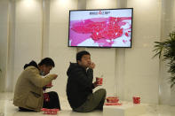 Workers eat their meal near a ceremony to mark the listing of JD Health, an arm of JD.com, on the Hong Kong Stock Exchange at the JD Headquarters in Beijing Tuesday, Dec. 8, 2020. Shares in China's biggest online health care platform rose 40% in their Hong Kong stock market debut Tuesday, reflecting investor enthusiasm for the fledgling industry as the country emerges from the coronavirus pandemic. (AP Photo/Ng Han Guan)