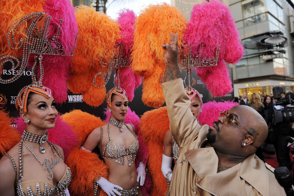 Singer Cee Lo Green acknowledges fans overhead as he arrives with the Jubilee! showgirls at the Caesars Entertainment "Escape To Total Rewards" concert in Los Angeles, Thursday, March 1, 2012. Simultaneous concert events were held in New York, Chicago, New Orleans and Los Angeles. (AP Photo/Chris Pizzello)