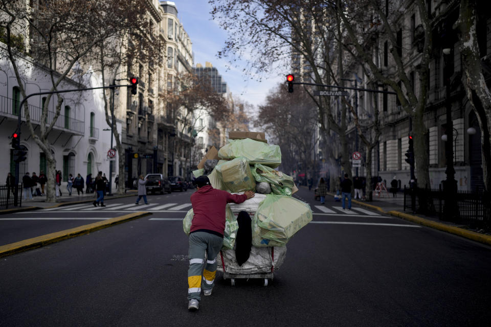 Un trabajador que recicla cartón para ganarse la vida empuja su carrito por una calle en Buenos Aires, Argentina, el jueves 14 de julio de 2022. (AP Foto/Natacha Pisarenko)