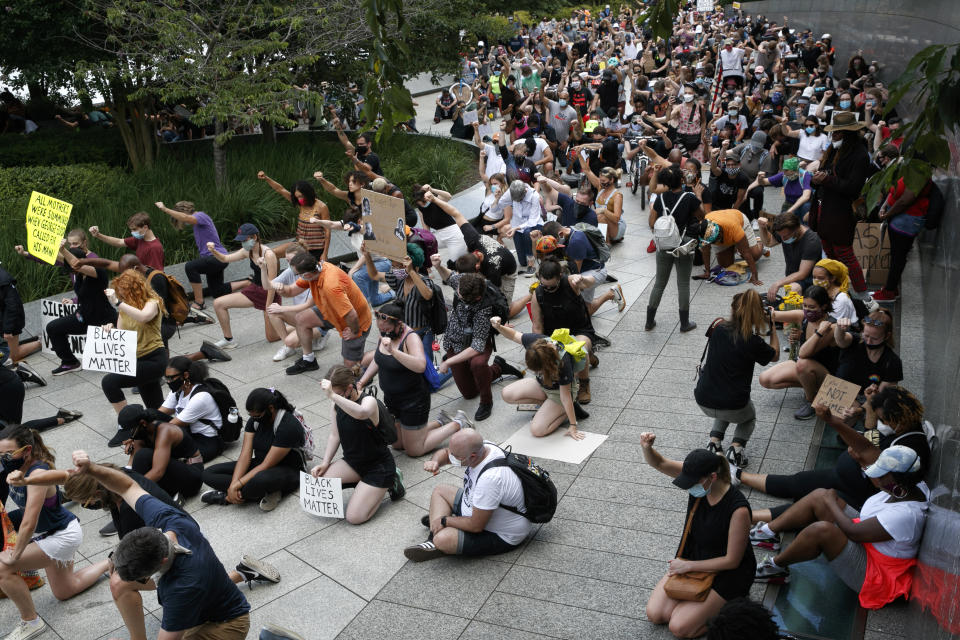 People hold up their first while taking a knee during a protest at the Martin Luther King, Jr., Memorial in Washington on Friday, June 19, 2020, while marking Juneteenth, the holiday celebrating the day in 1865 that enslaved Black people in Galveston, Texas, learned they had been freed from bondage, more than two years after the Emancipation Proclamation. (AP Photo/Jacquelyn Martin)