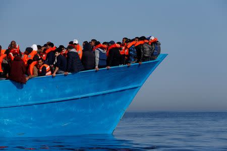 FILE PHOTO: Migrants on a wooden boat await rescue by the Malta-based NGO Migrant Offshore Aid Station (MOAS) in the central Mediterranean in international waters off the coast of Sabratha in Libya, April 15, 2017. REUTERS/Darrin Zammit Lupi/File Photo