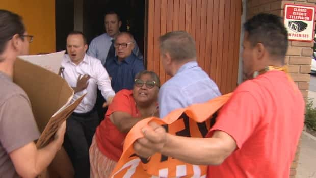 Protestors tried entering Our Lady Queen of Poland Parish during Sunday mass, but they were met at the front door and pushed out. (Jamie McCannel/CBC - image credit)