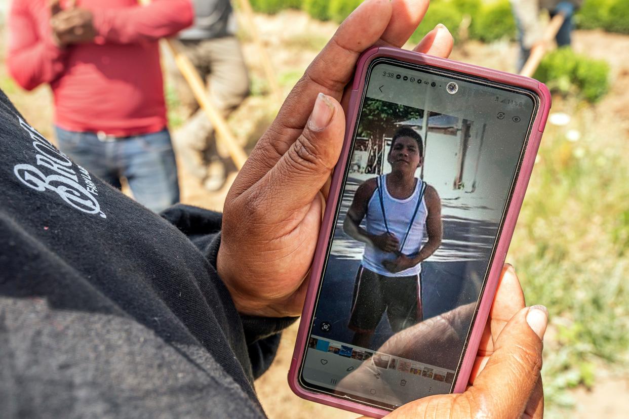 A worker, who declined to be named, shows a photo of Sebastian Francisco Perez, who died in June 2021 while working in an extreme heat wave near St. Paul.