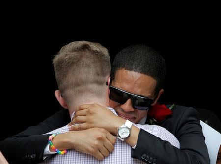 Mourners hug after a funeral service for Christopher Leinonen, who was killed at the Pulse gay nightclub, at Cathedral Church of St. Luke in Orlando, Florida, U.S. June 18, 2016. REUTERS/Jim Young