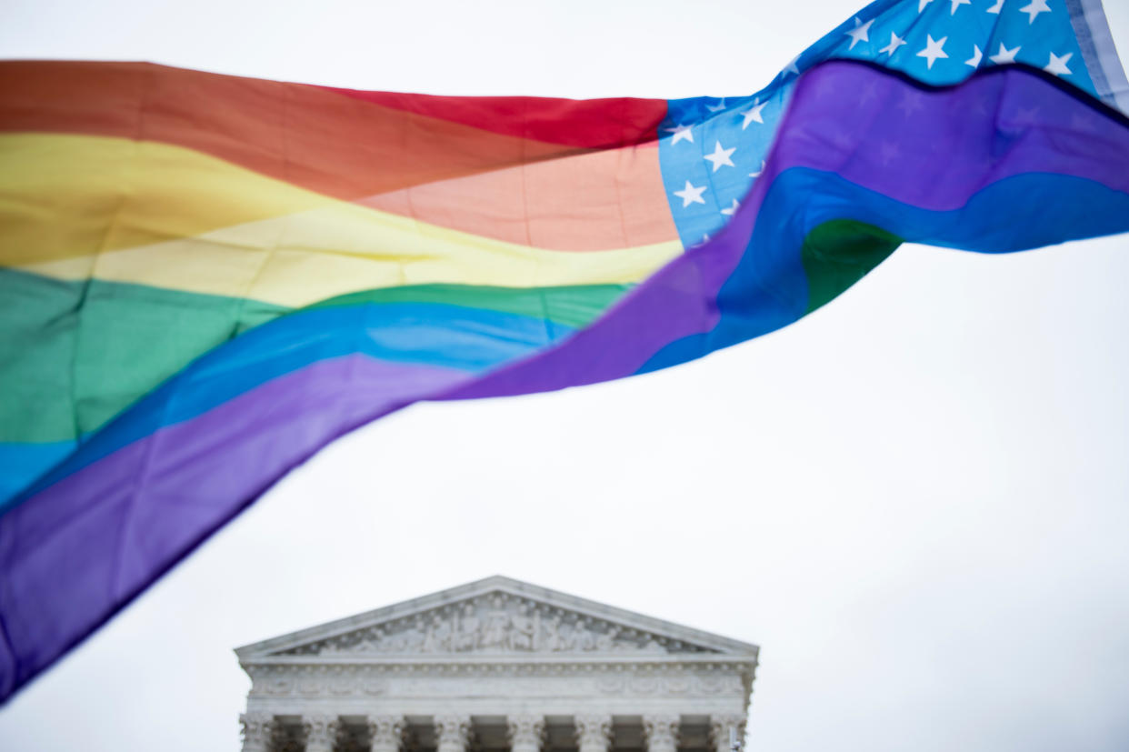 Supreme Court building behind a rainbow flag.