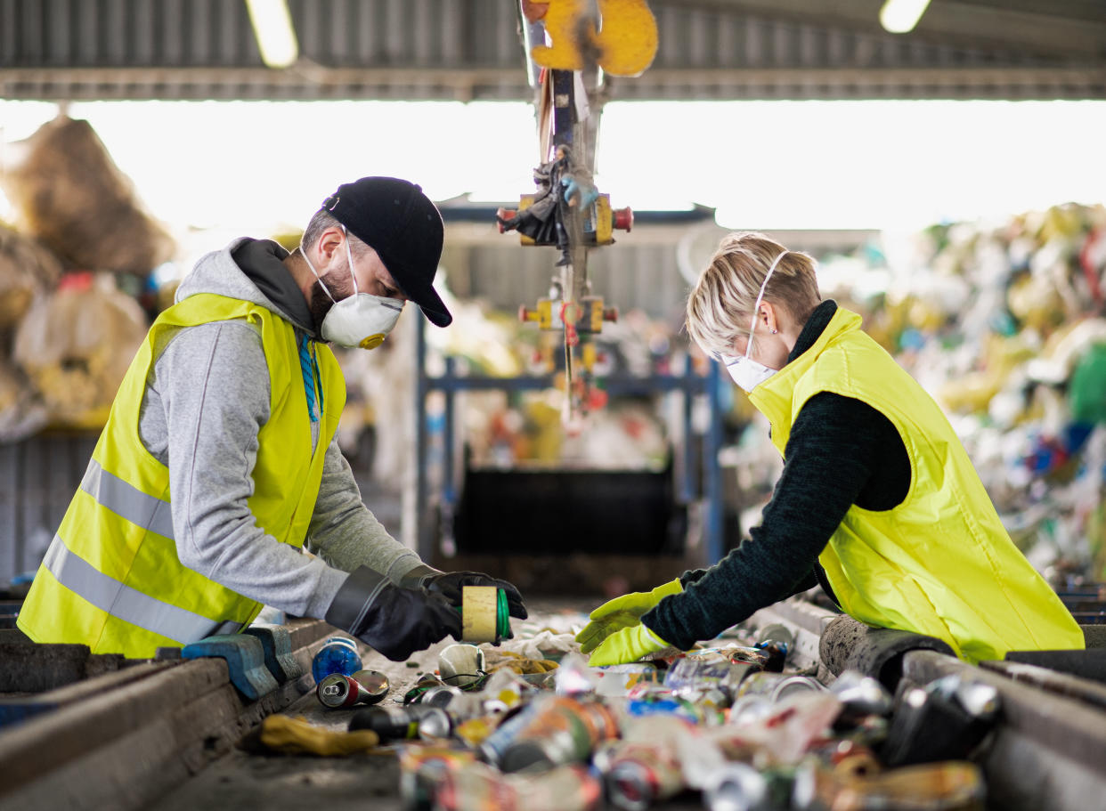 Two people separate waste for recycling. (Getty Images)