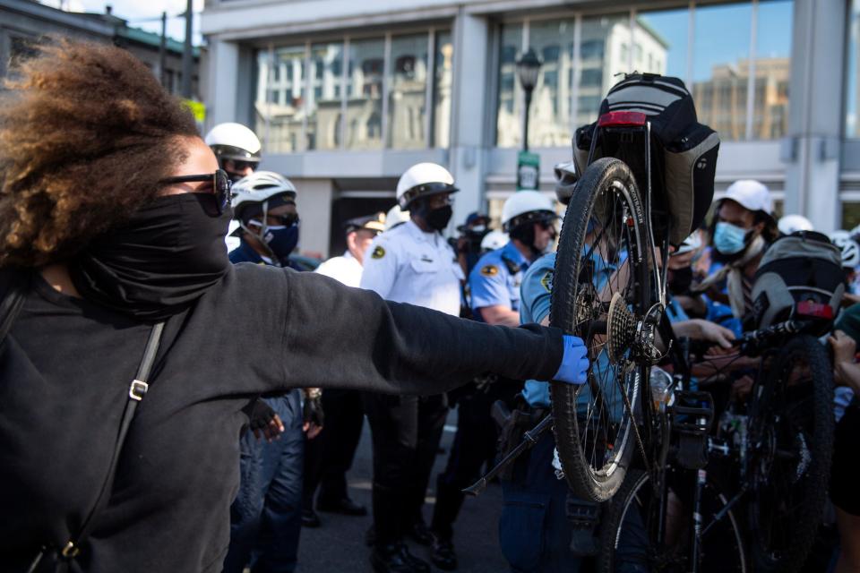 Police officers use bicycles to push back a crowd of demonstrators Saturday in Philadelphia.