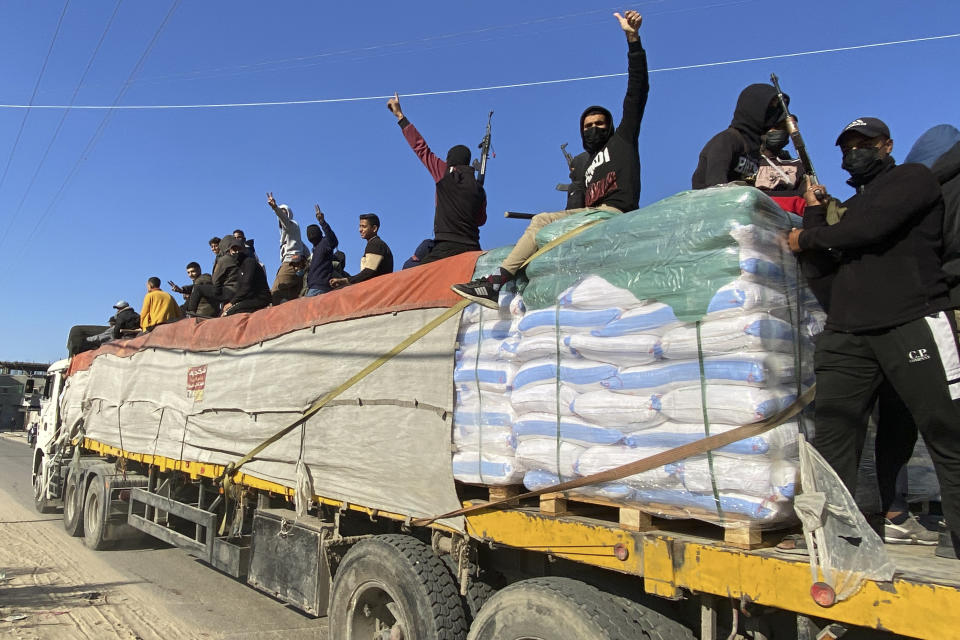 Hamas fighters ride on top of a humanitarian aid truck in Rafah, Gaza Strip, Tuesday, Dec. 19, 2023. (AP Photo)