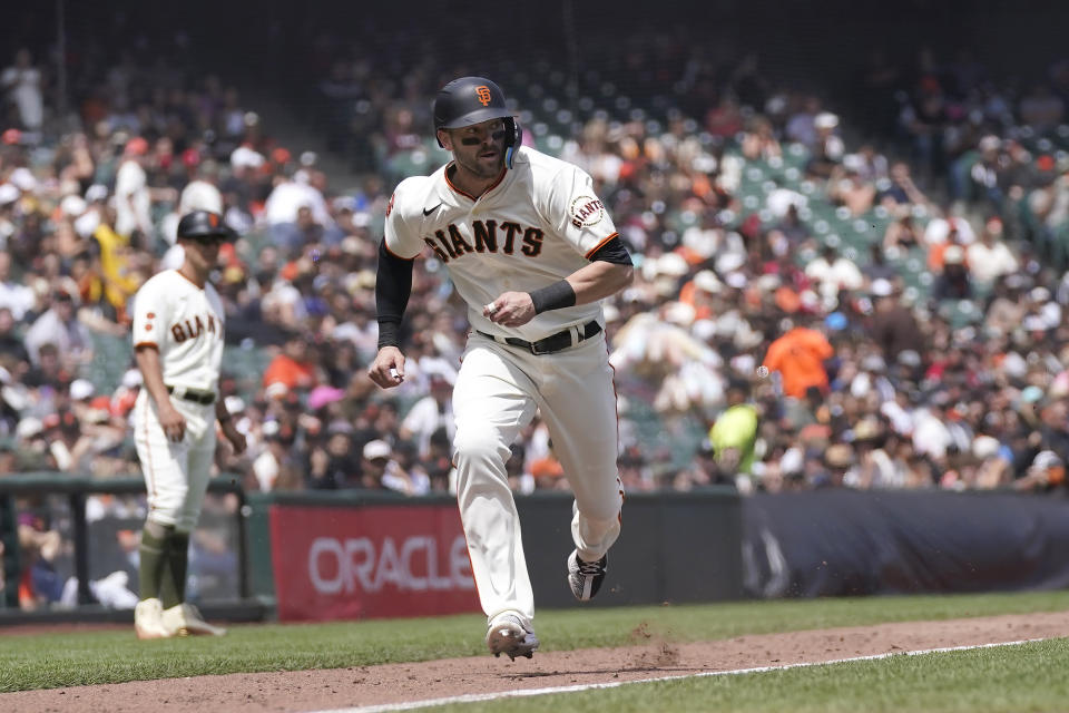 San Francisco Giants' Mitch Haniger runs home to score against the Miami Marlins during the sixth inning of a baseball game in San Francisco, Sunday, May 21, 2023. (AP Photo/Jeff Chiu)