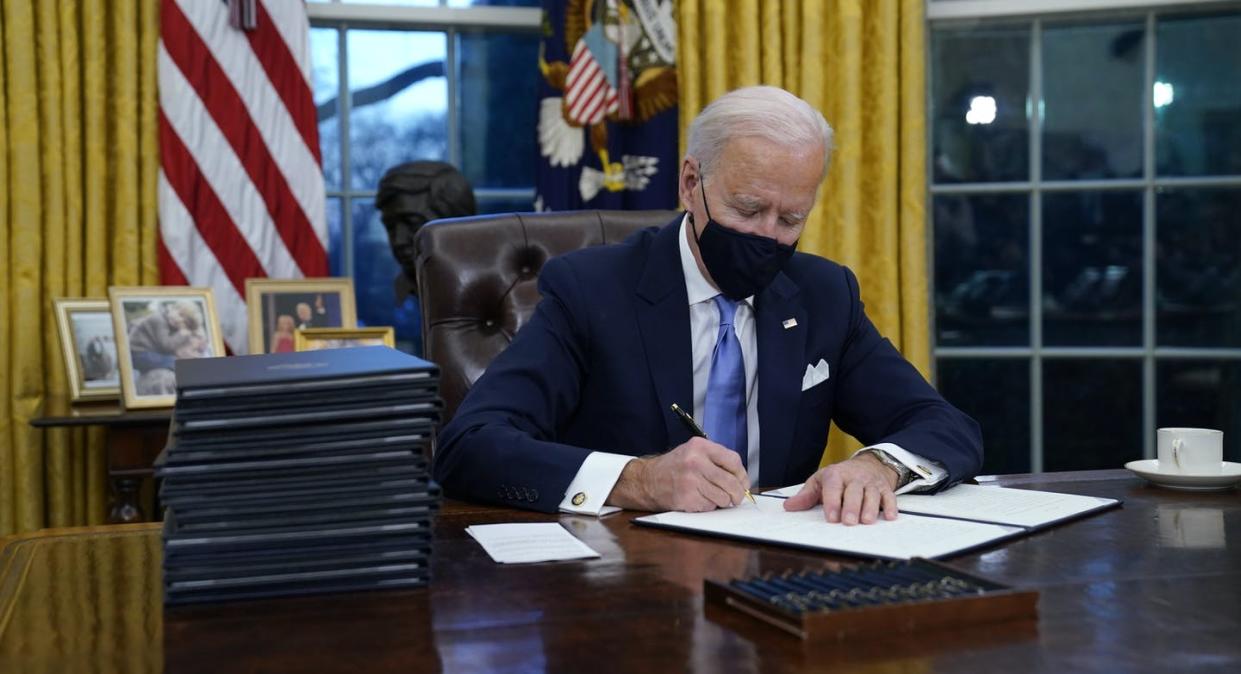 <span class="caption">U.S. President Joe Biden signs his first executive order in the Oval Office of the White House on Jan. 20, 2021, in Washington. </span> <span class="attribution"><span class="source">(AP Photo/Evan Vucci)</span></span>
