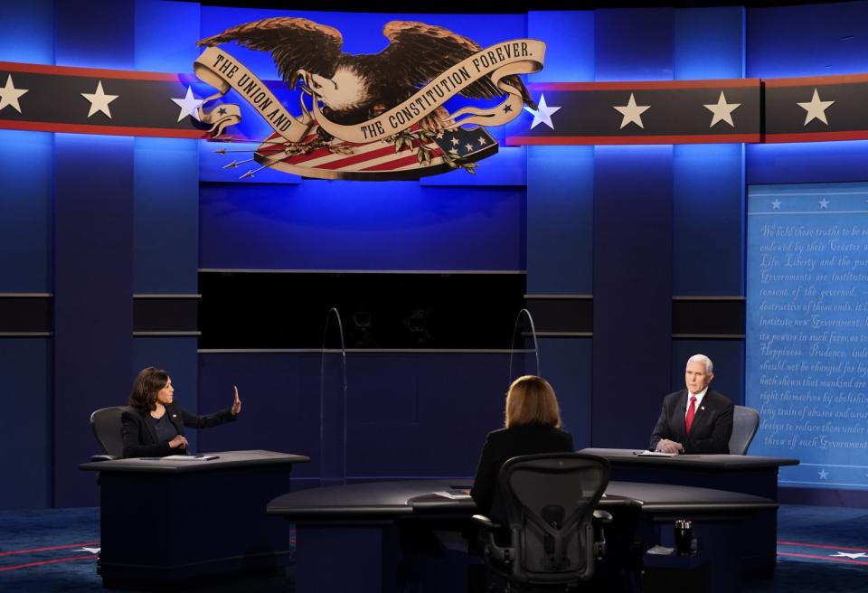 Kamala Harris raises her hand in a stop motion toward Mike Pence