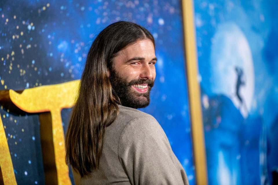 Jonathan Van Ness looking over their shoulder and smiling