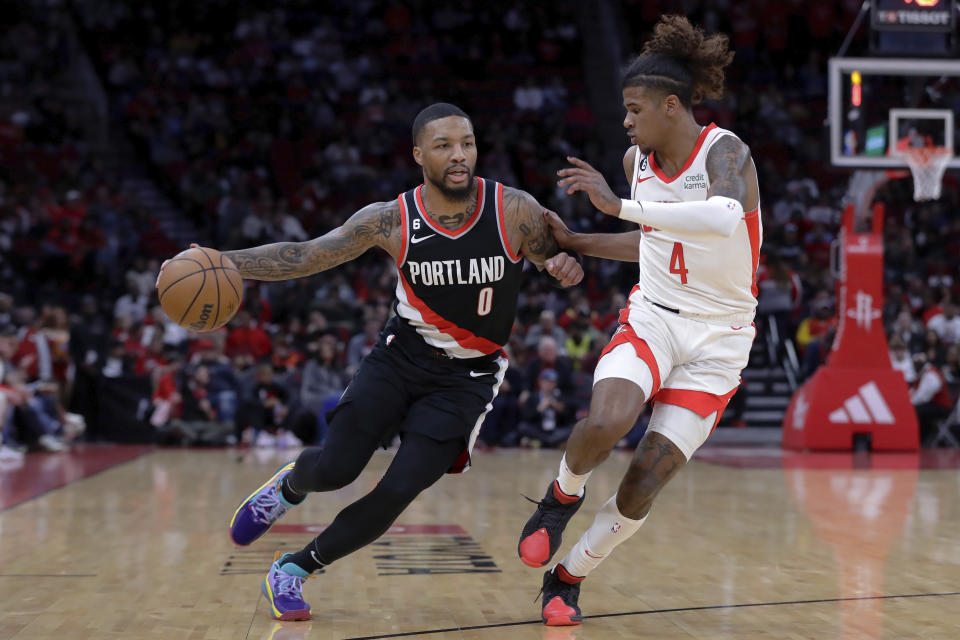 Portland Trail Blazers guard Damian Lillard (0) drives around Houston Rockets guard Jalen Green (4) during the first half of an NBA basketball game Saturday, Dec. 17, 2022, in Houston. (AP Photo/Michael Wyke)