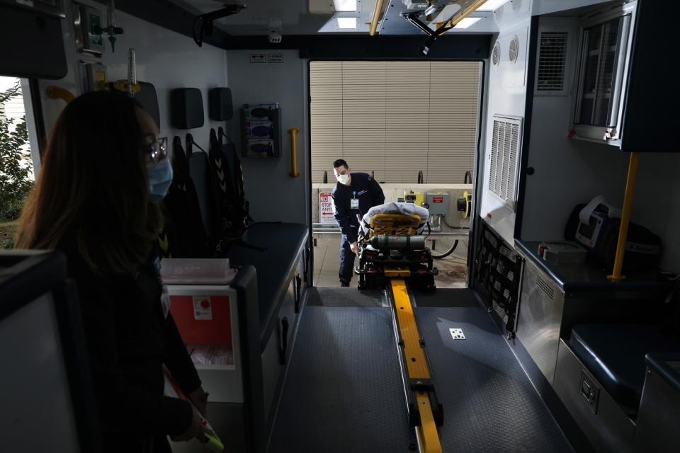 EMTs Andrea Casas, left, and Jim Lopez conduct a daily equipment check on ECMO-1.