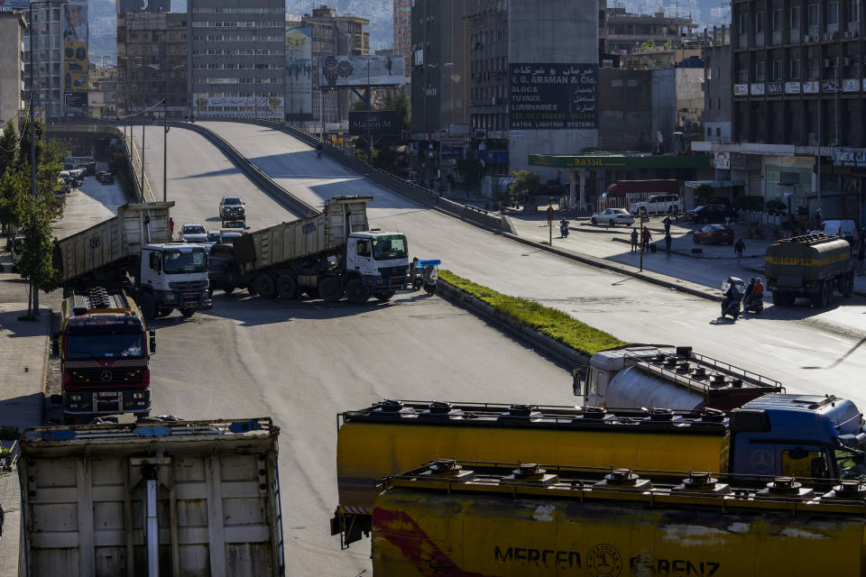 Trucks block a main highway during a general strike by public transport unions protesting the country's deteriorating economic and financial conditions in Beirut, Lebanon, Wednesday, Feb. 2, 2022. (AP Photo/Hassan Ammar)