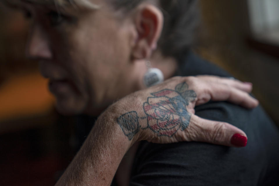A tattoo of a rose with an American flag decorates the hand of Barbie Rohde, as she sits in a restaurant Saturday, June 10, 2023, in Jacksonville, Texas. Rohde has tattoos all over her body, and when people ask her about them, she doesn't hesitate to tell them how her son died, and how he should not have. She has never been ashamed, she said. (AP Photo/David Goldman)