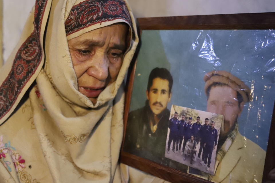 Mother of Mohammed Hassan, a Pakistani porter who was died on July 27 during the summiting K2, the world's second-highest peak, weeps while she shows a picture of her son with her husband, during an interview with the Associated Press, in Tasar, a village of Shigar district in Gilgit-Baltistan region in the northern Pakistan, Saturday, Aug. 12, 2023. An investigation has been launched into the death of Mohammed Hassan following allegations that dozens of climbers eager to reach the summit had walked past the man after he was gravely injured in a fall. (AP Photo/M.H. Balti)