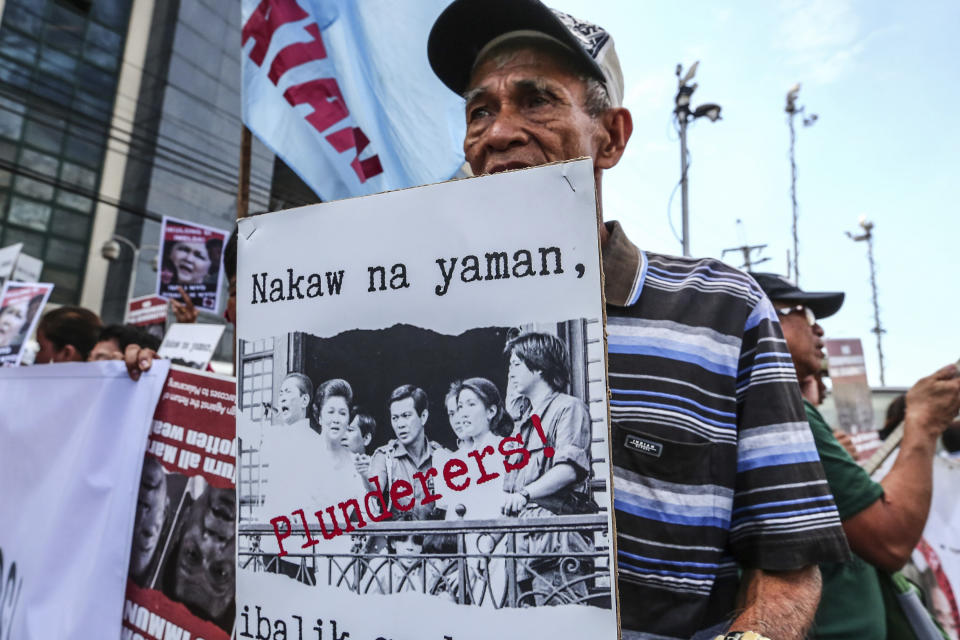 A protester displays a placard outside the anti-graft court Sandiganbayan as former Philippine First Lady Imelda Marcos was ordered to appear to explain her side for not attending last week's promulgation of the graft charges against her Friday, Nov. 16, 2018 in suburban Quezon city northeast of Manila, Philippines. A Philippine court found Imelda Marcos guilty of graft and ordered her arrest last week in a rare conviction among many corruption cases that she's likely to appeal to avoid jail and losing her seat in Congress. The placard reads: Return The Ill-gotten Wealth.! (AP Photo/Maria S. Tan)