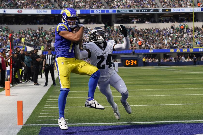 Rams wide receiver Puka Nakua (left) catches a touchdown pass while Philadelphia Eagles cornerback James Bradbury defends